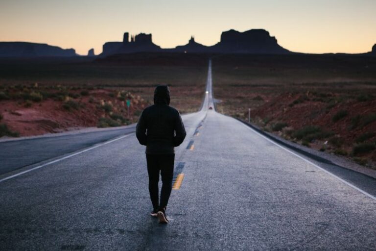 Demotivation - person walking in the center of the road