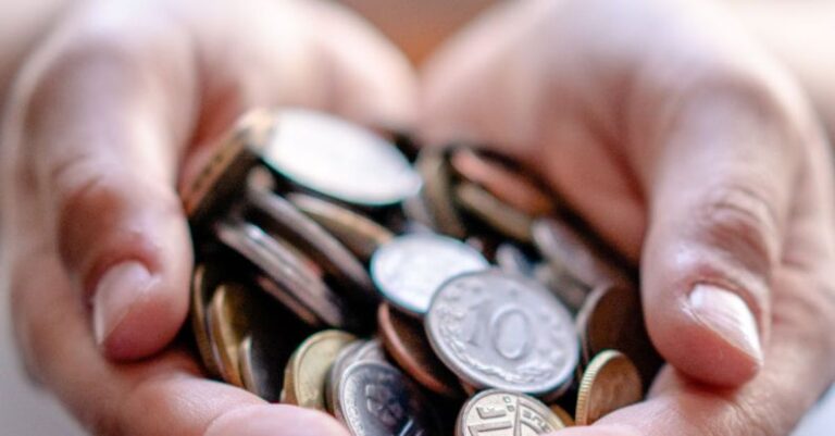 Benefits - Crop anonymous person demonstrating heap of coins in hands demonstrating concept of savings