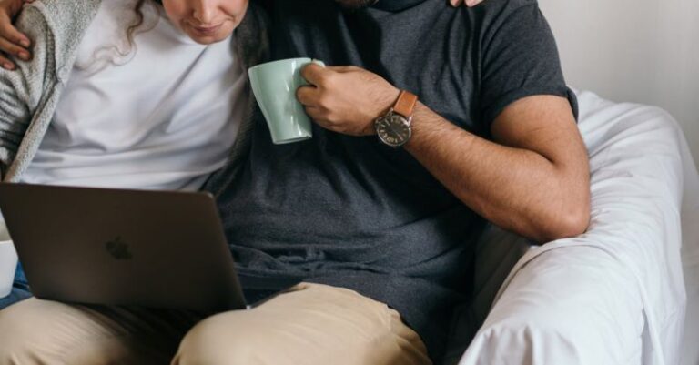 Communication - Multiethnic couple surfing net on laptop in new house